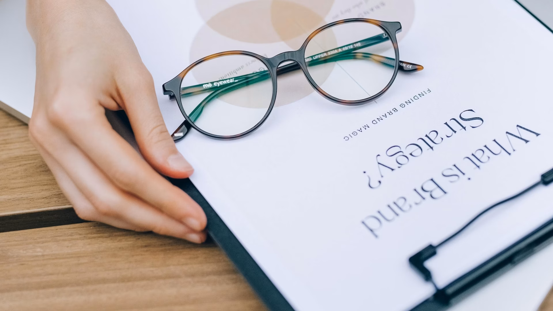 An agent opening a book that says "what is brand strategy" on the front in search of the best real estate slogans and taglines