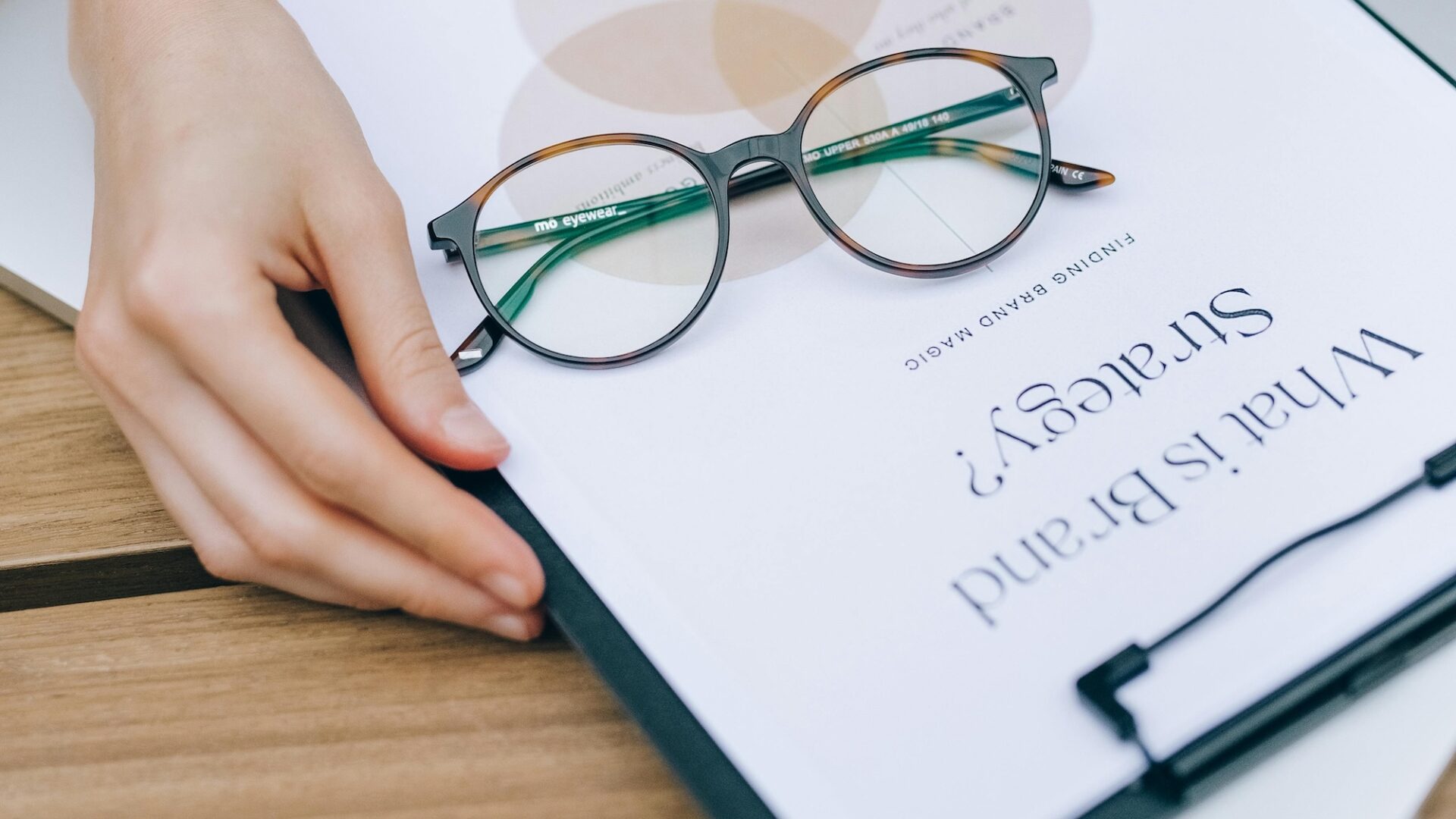 An agent opening a book that says "what is brand strategy" on the front in search of the best real estate slogans and taglines