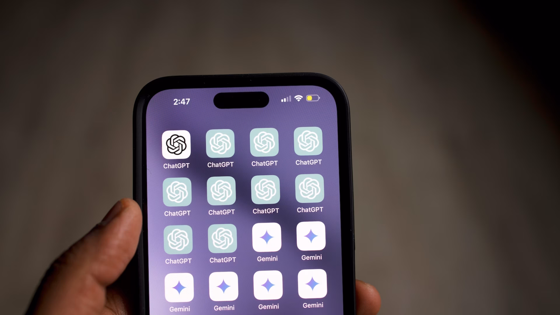 Hand holding smartphone with many ChatGPT icons on the screen, demonstrating the interest in ChatGPT real estate strategies