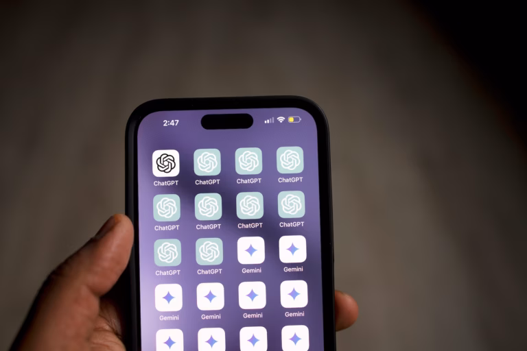 Hand holding smartphone with many ChatGPT icons on the screen, demonstrating the interest in ChatGPT real estate strategies