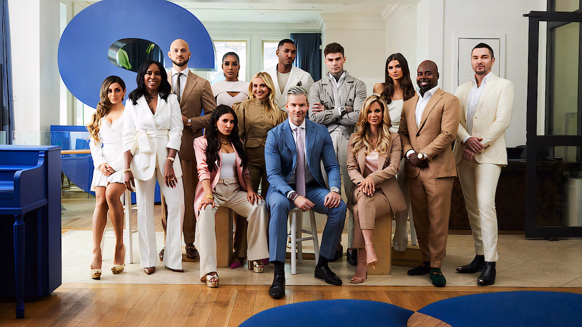 Ryan Serhant sits in his brokerage office surrounded by his real estate team