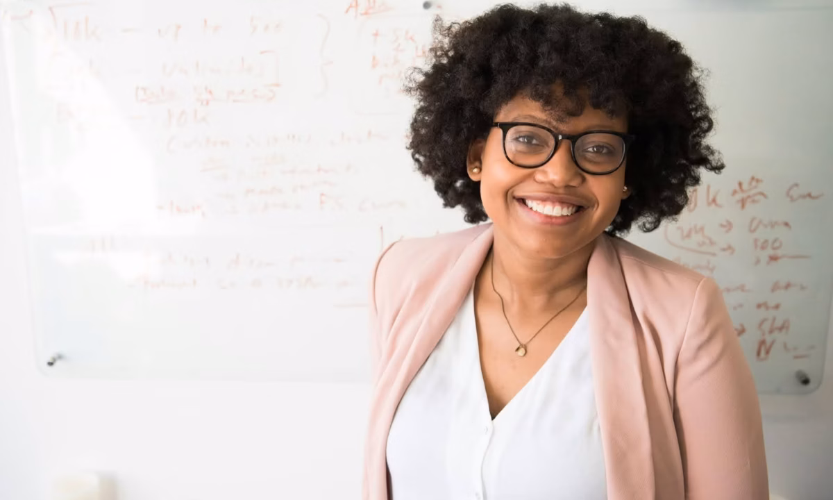 A teacher stands in front of a whiteboard instructing students on how to become a real estate agent