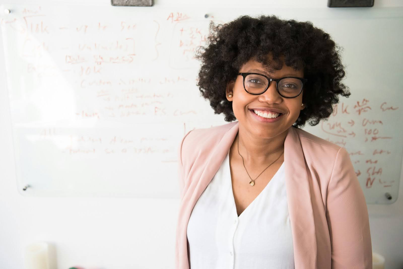 A teacher stands in front of a whiteboard instructing students on how to become a real estate agent