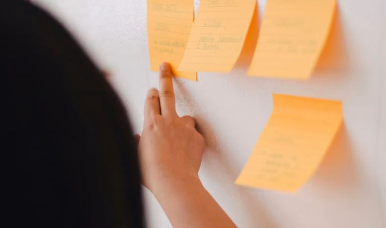 Real estate agent using a whiteboard and post-it notes to workshop her unique value proposition