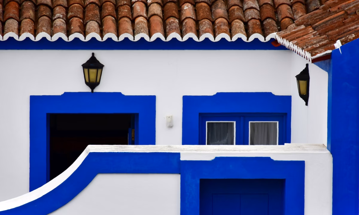 Blue and white stucco outer gate blocks the entrance to a home, representing off-market listings in real estate