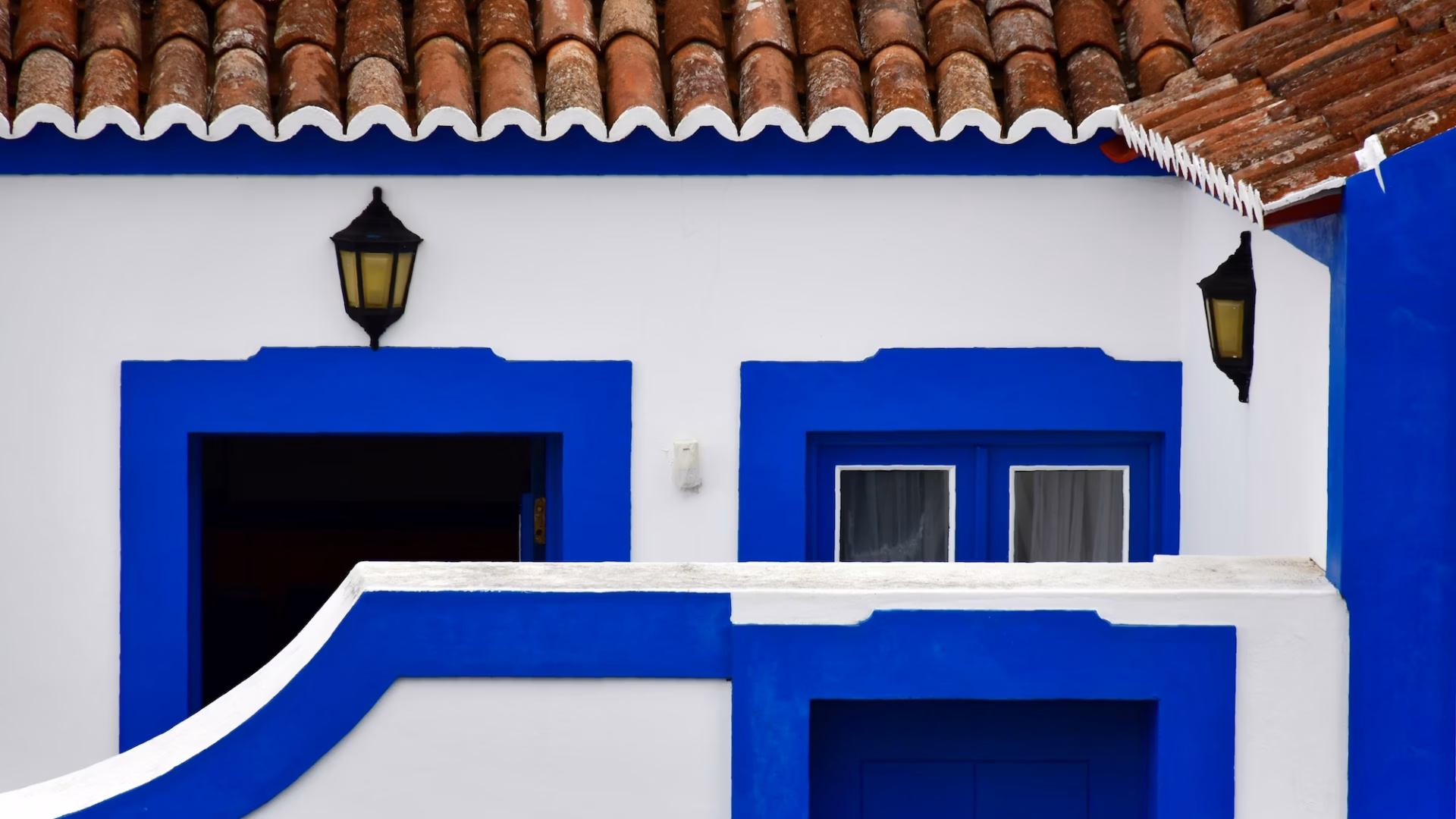 Blue and white stucco outer gate blocks the entrance to a home, representing off-market listings in real estate