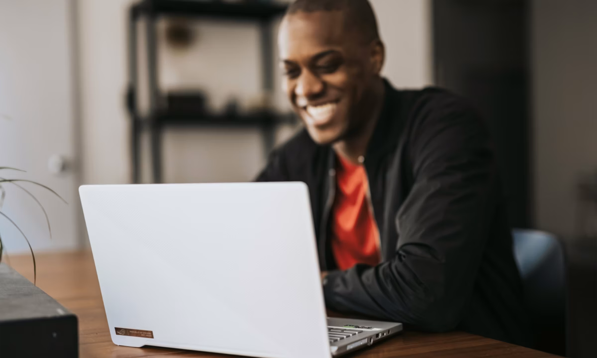 a real estate agent sits at a wooden desk working on lead nurturing emails to send to prospects