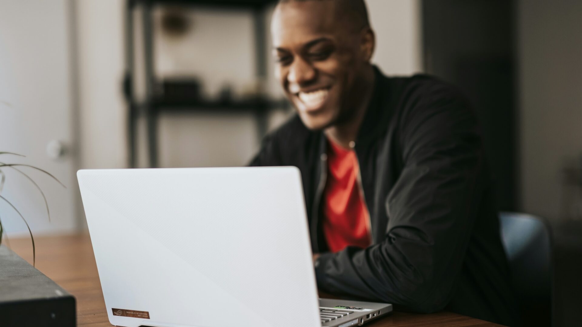 a real estate agent sits at a wooden desk working on lead nurturing emails to send to prospects