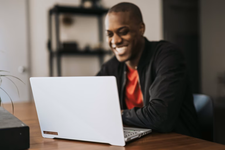 a real estate agent sits at a wooden desk working on lead nurturing emails to send to prospects