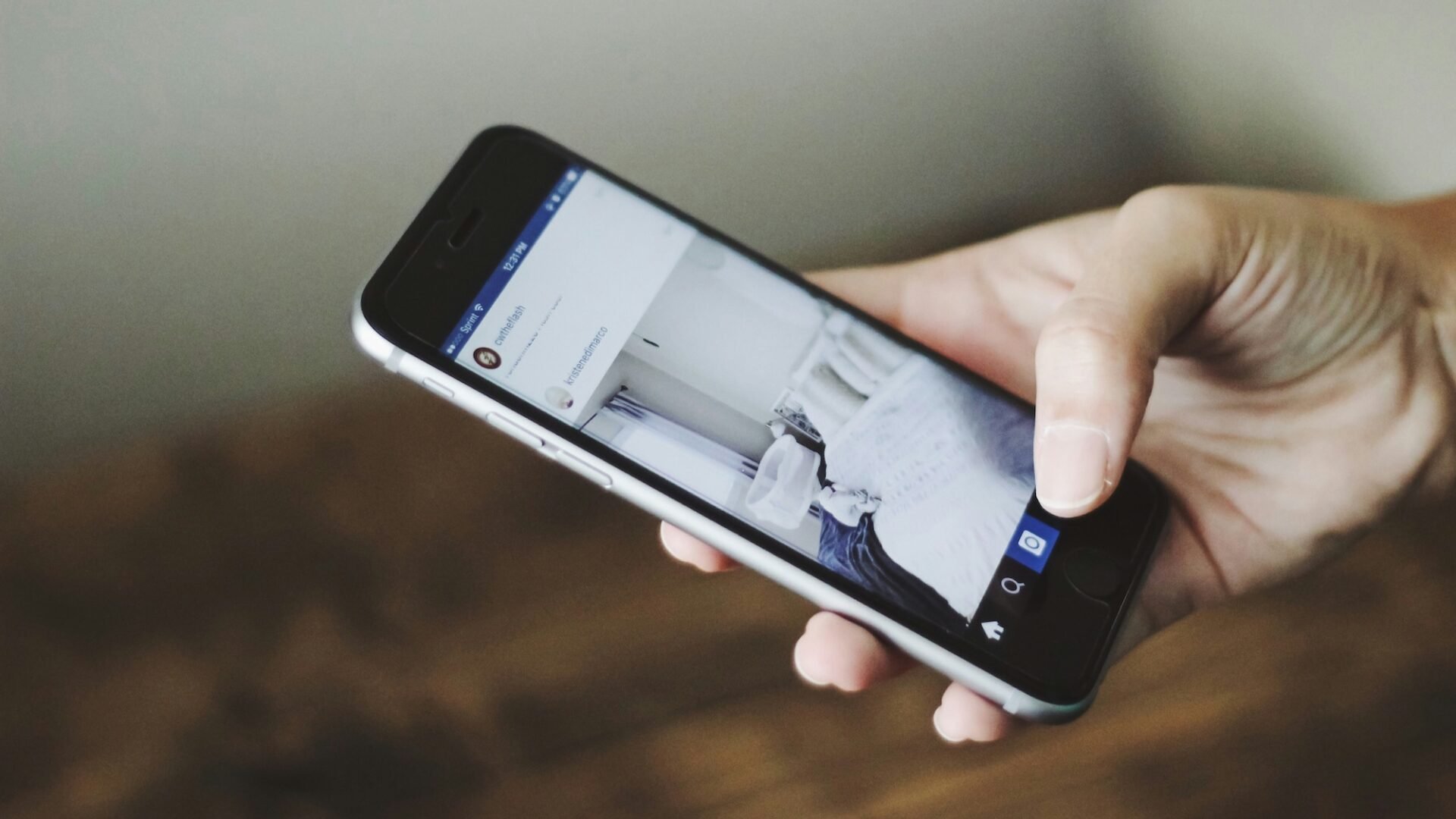 A close up of an agent's hand posting real estate captions for social media from their smartphone