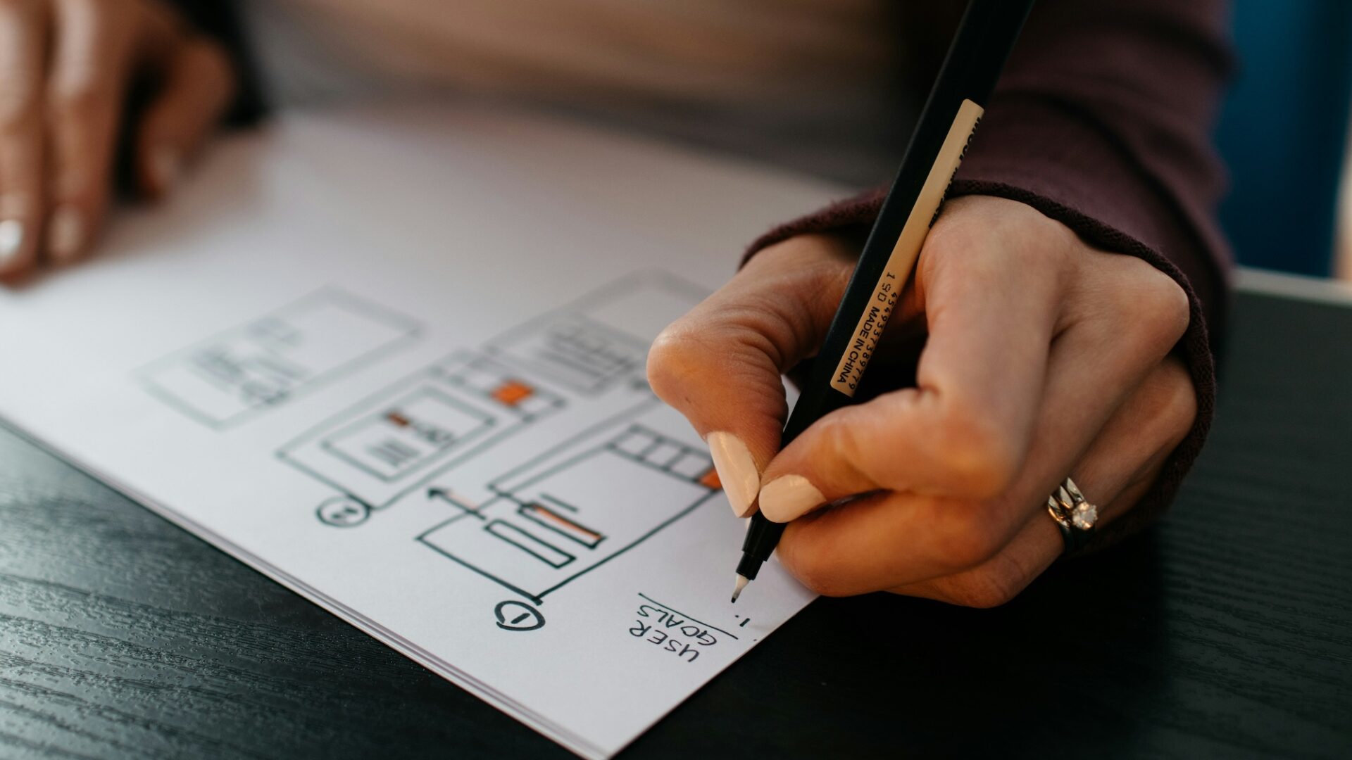 A website designer sketches out a wireframe on a tablet, demonstrating the work that real estate website providers such as agentfire and luxury presence do