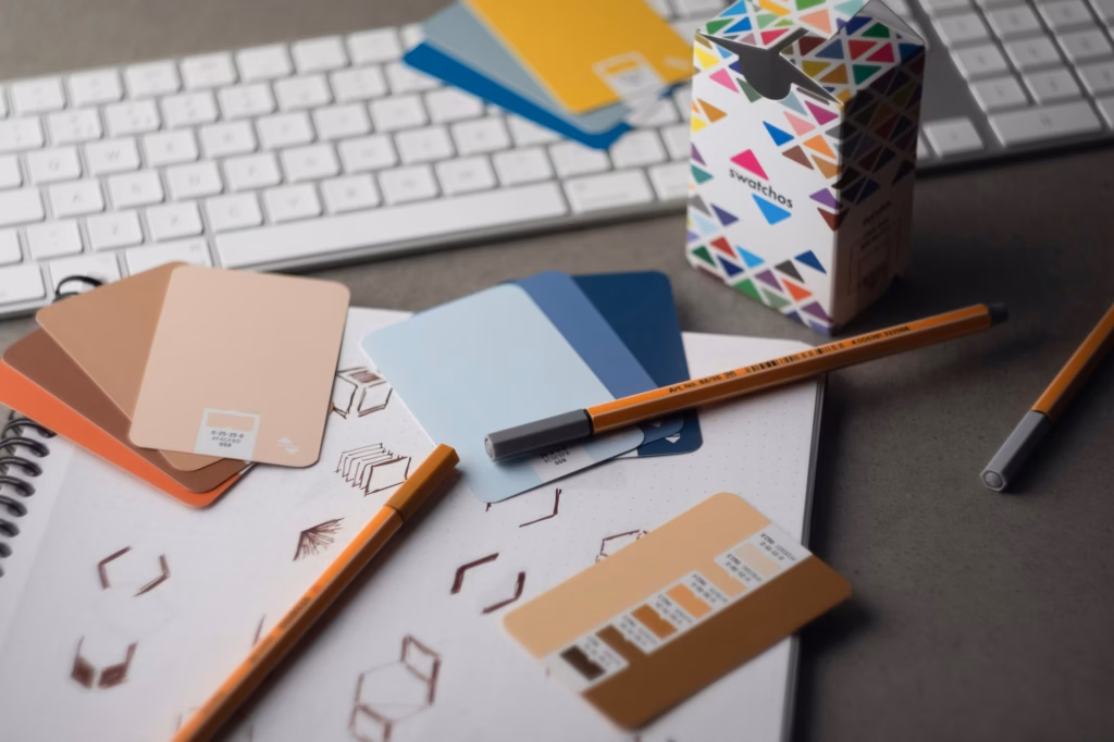 A desk with color cards, pens and sketches on it along with a keyboard, showing the journey to creating the Best real estate brands