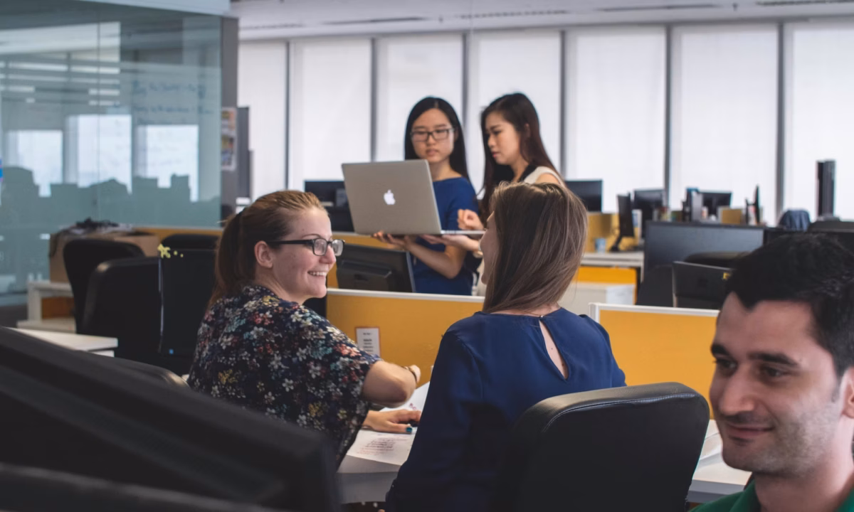 In a busy real estate brokerage office, a broker-owner recruits a top producing agent