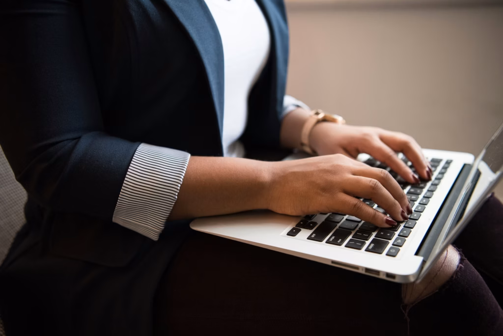 real estate agent types on a laptop working on the brand storytelling in her online marketing strategy