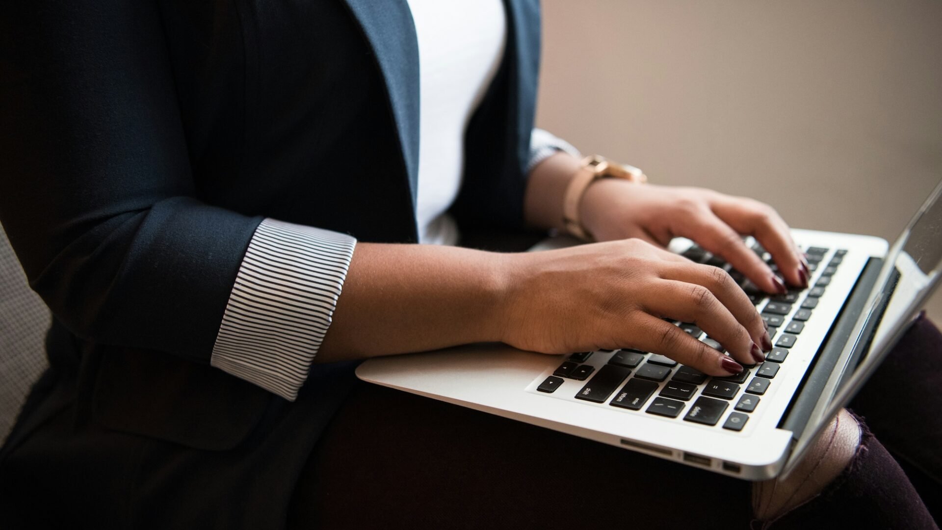 real estate agent types on a laptop working on the brand storytelling in her online marketing strategy