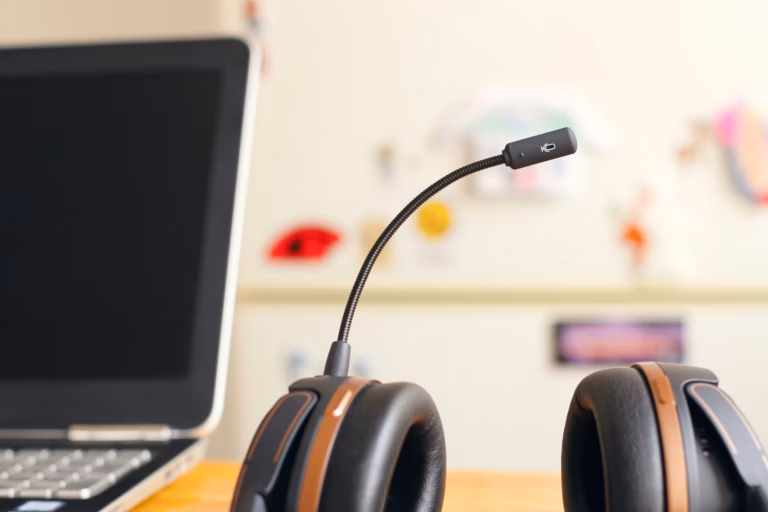 A headset with mic sits next to a laptop as a real estate professional ensures TCPA compliance in their lead generation strategies