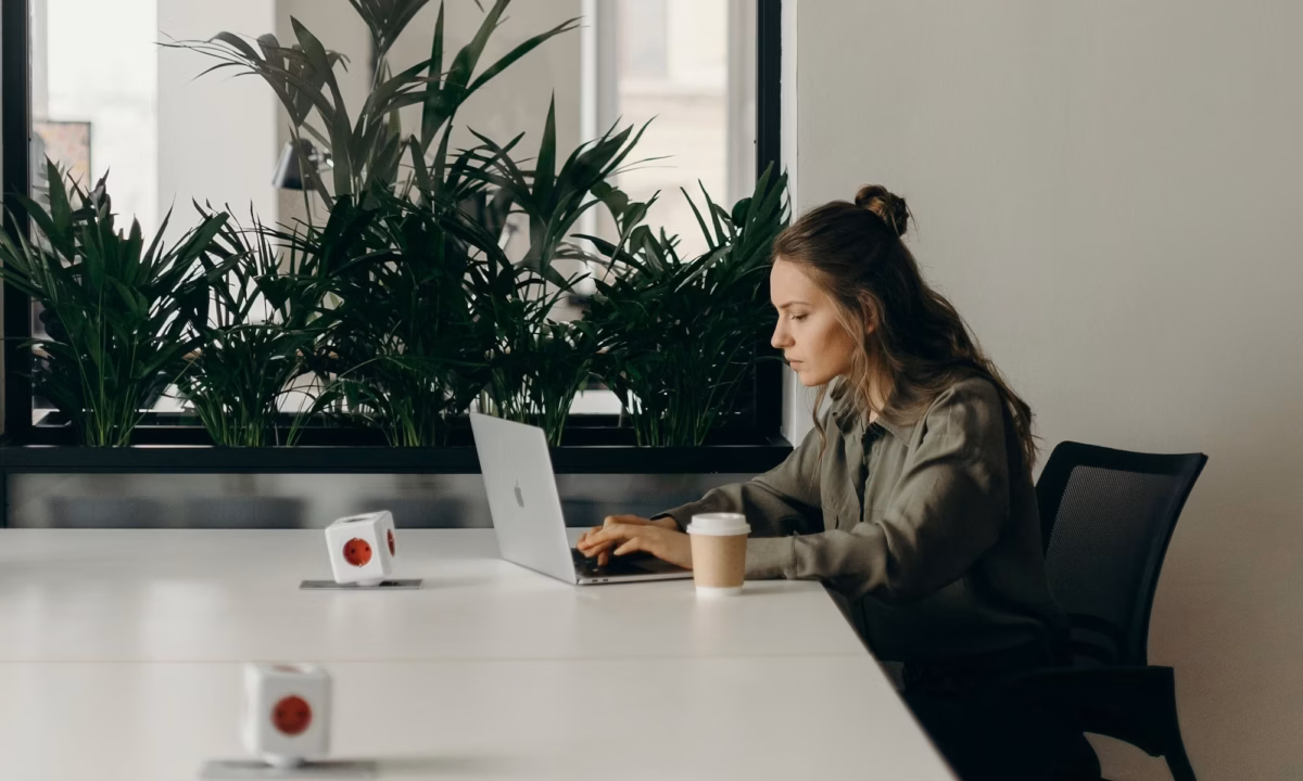 Real estate agent sitting at a white conference table reviewing email marketing laws on a laptop
