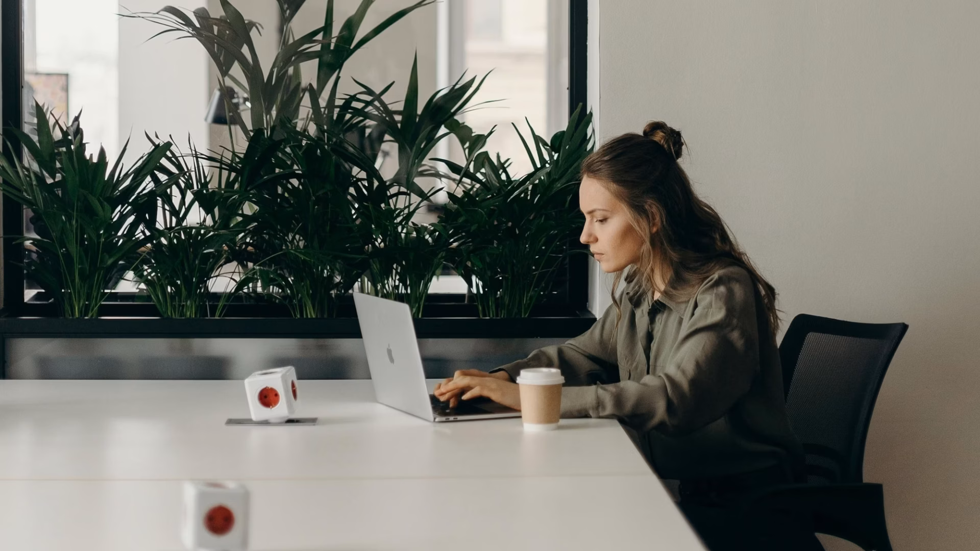 Real estate agent sitting at a white conference table reviewing email marketing laws on a laptop