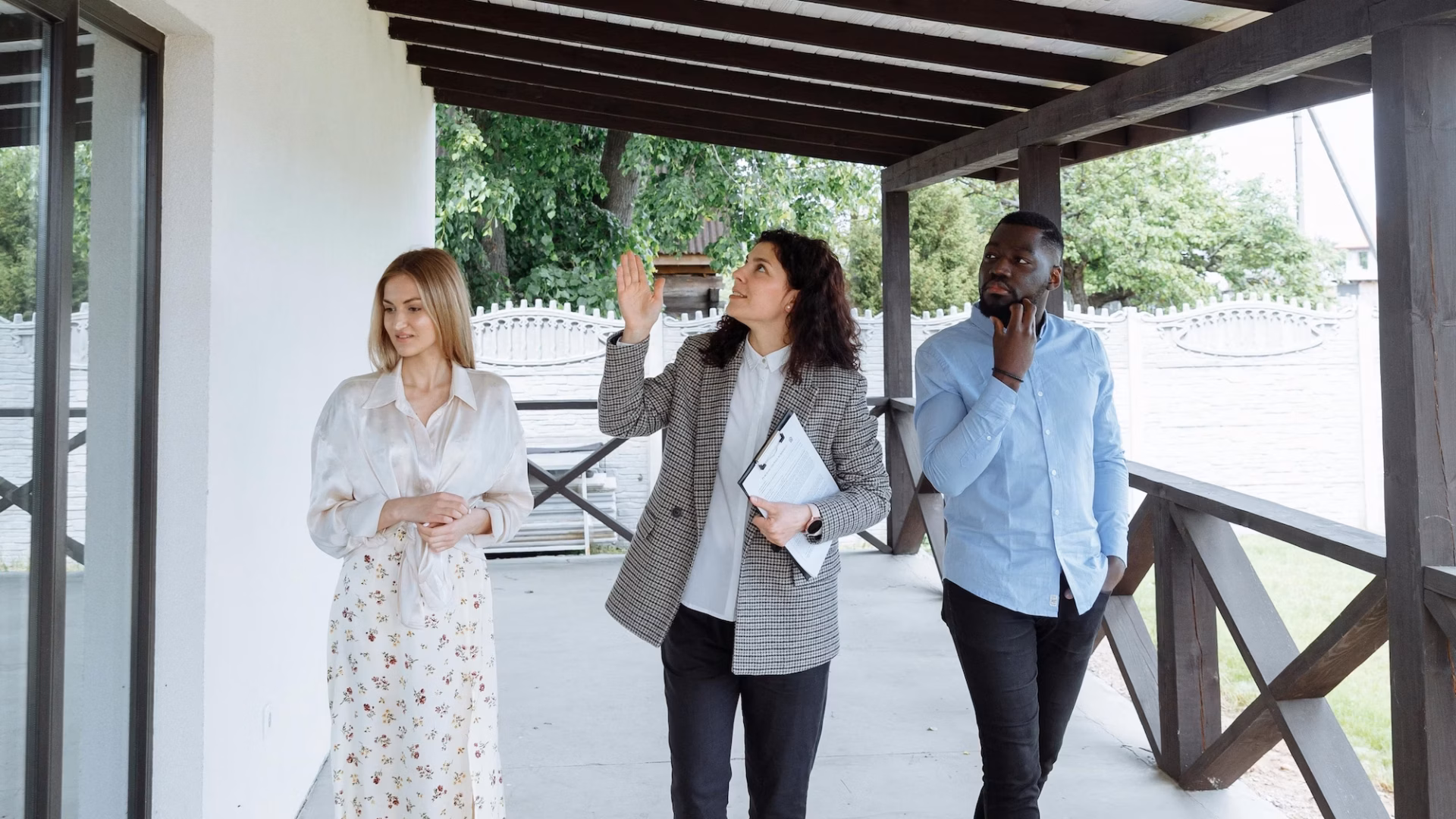 A real estate agent walks between two house hunters, using storytelling in marketing to help the buyers see how they fit into the narrative of the property