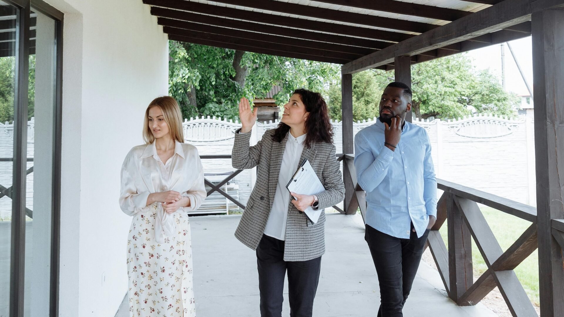 A real estate agent walks between two house hunters, using storytelling in marketing to help the buyers see how they fit into the narrative of the property