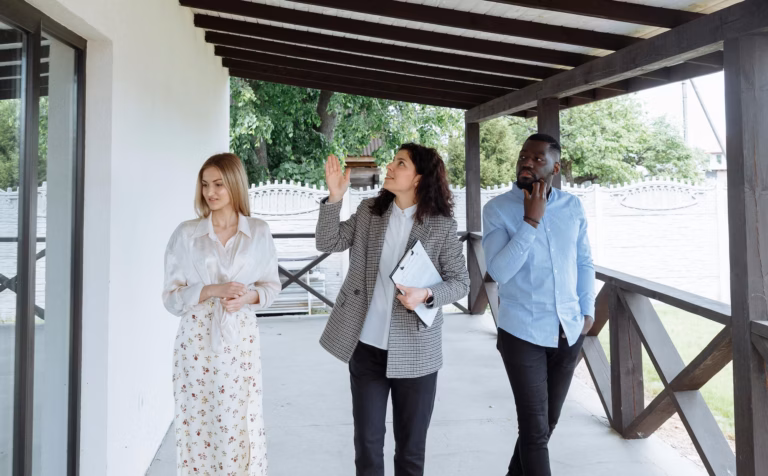 A real estate agent walks between two house hunters, using storytelling in marketing to help the buyers see how they fit into the narrative of the property