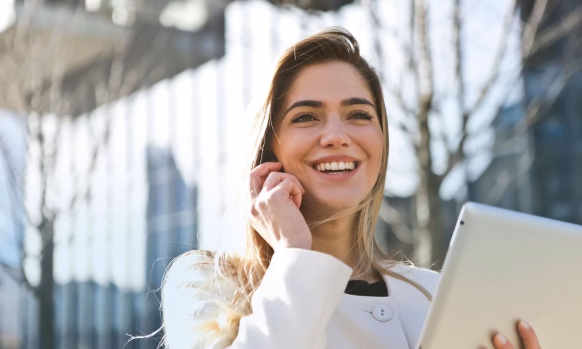 A real estate agent talks to her client on her smartphone while using Luxury Presence's white-labeled app on her tablet