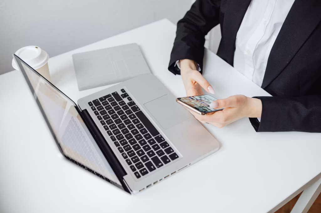 Real estate agent in front of laptop texting leads, leveraging email and SMS marketing strategies to move prospects down the sales funnel