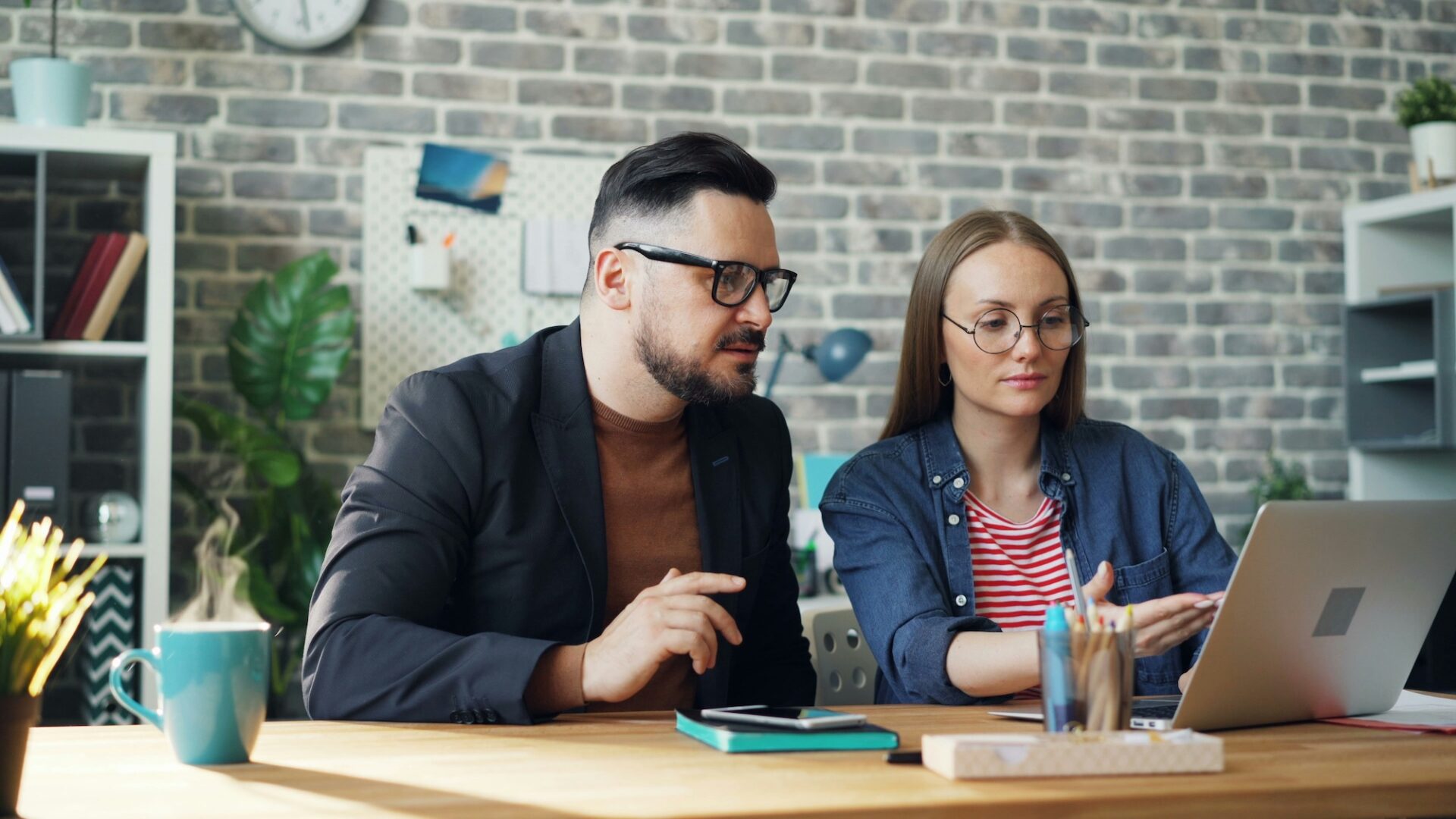 a real estate agent and broker sit in front of a laptop reviewing the ideal email marketing journey to convert leads