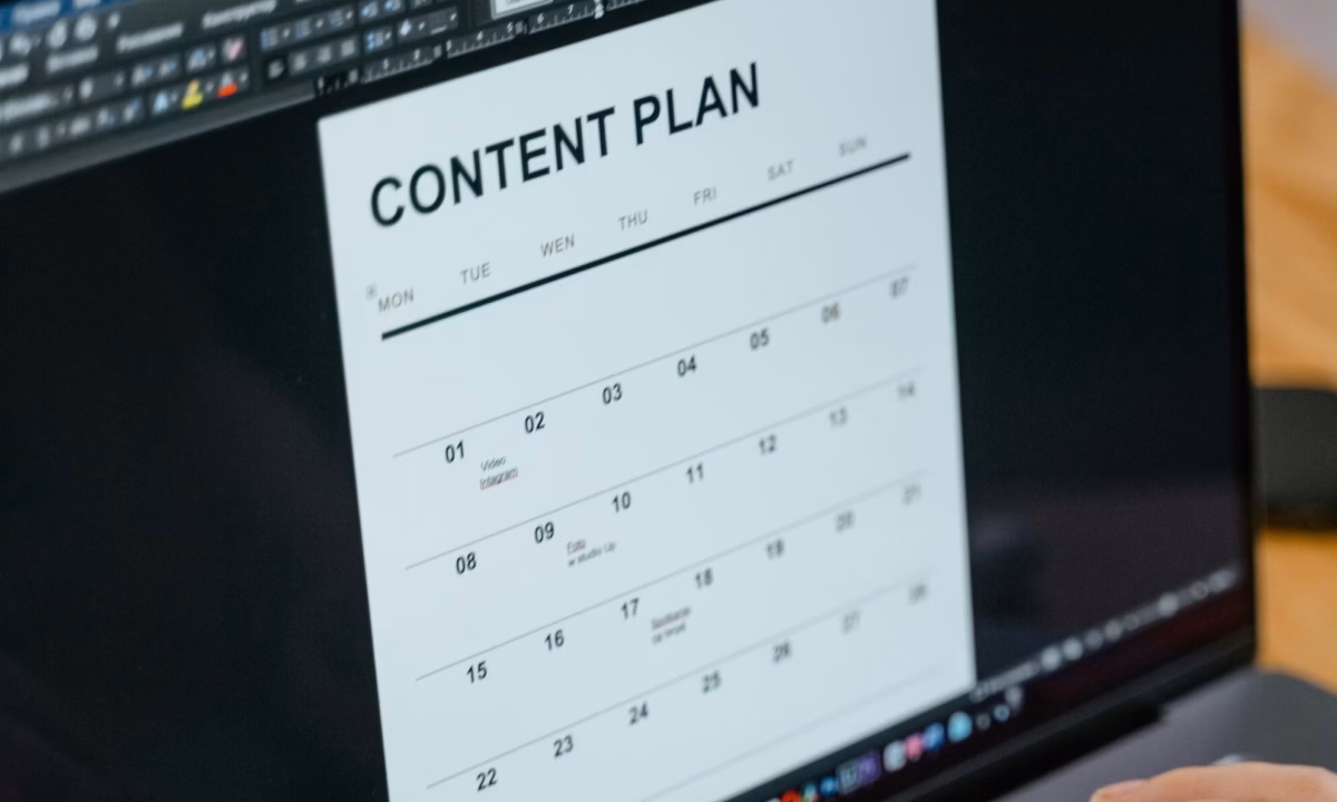A real estate agent types of a laptop using email marketing tools such as a content calendar to promote her business