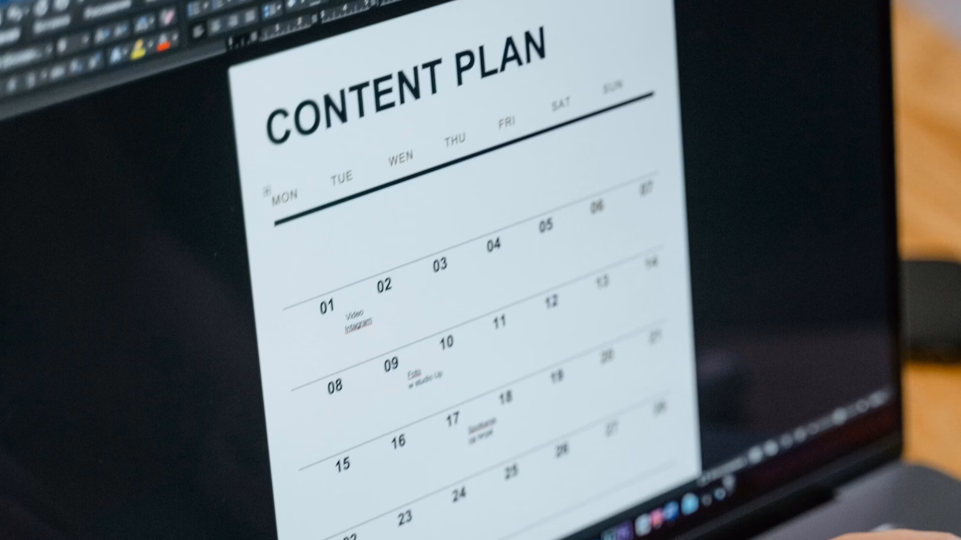 A real estate agent types of a laptop using email marketing tools such as a content calendar to promote her business