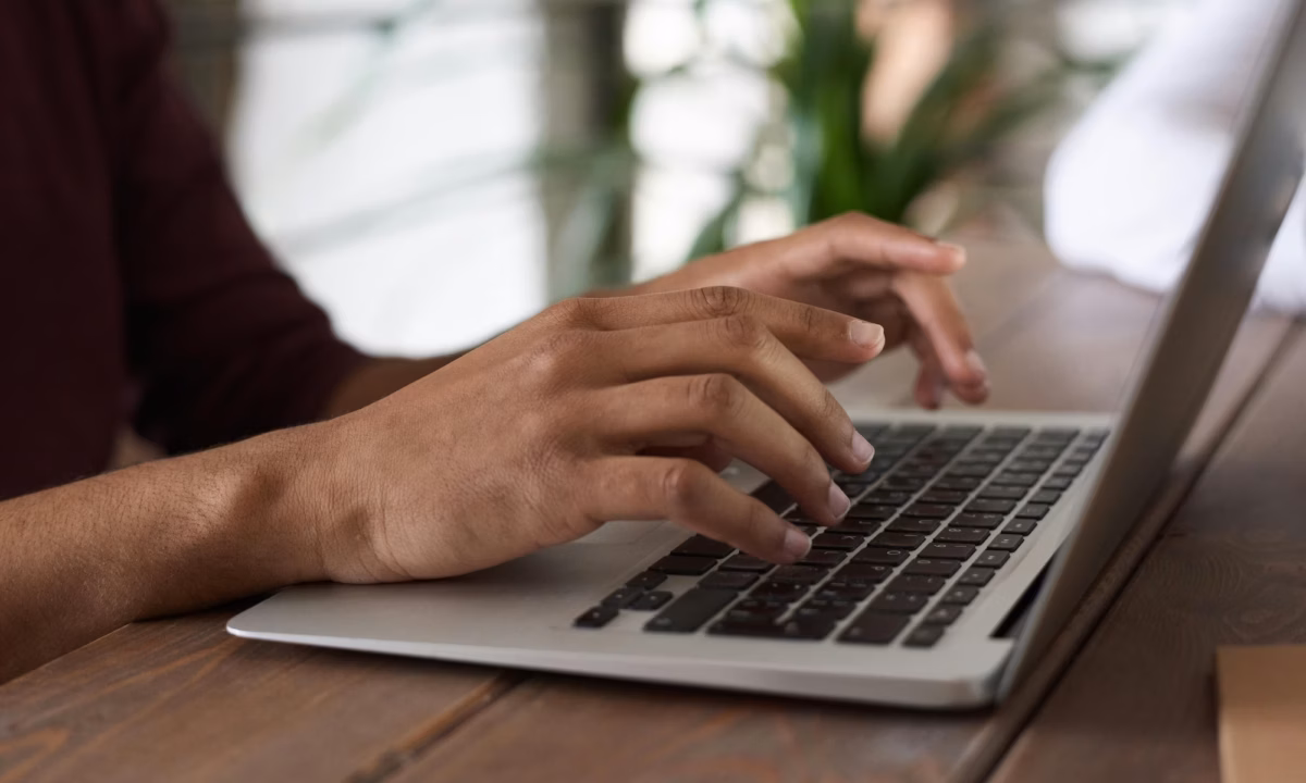 A real estate agent types out email marketing subject lines on their laptop for their latest outreach campaign to leads