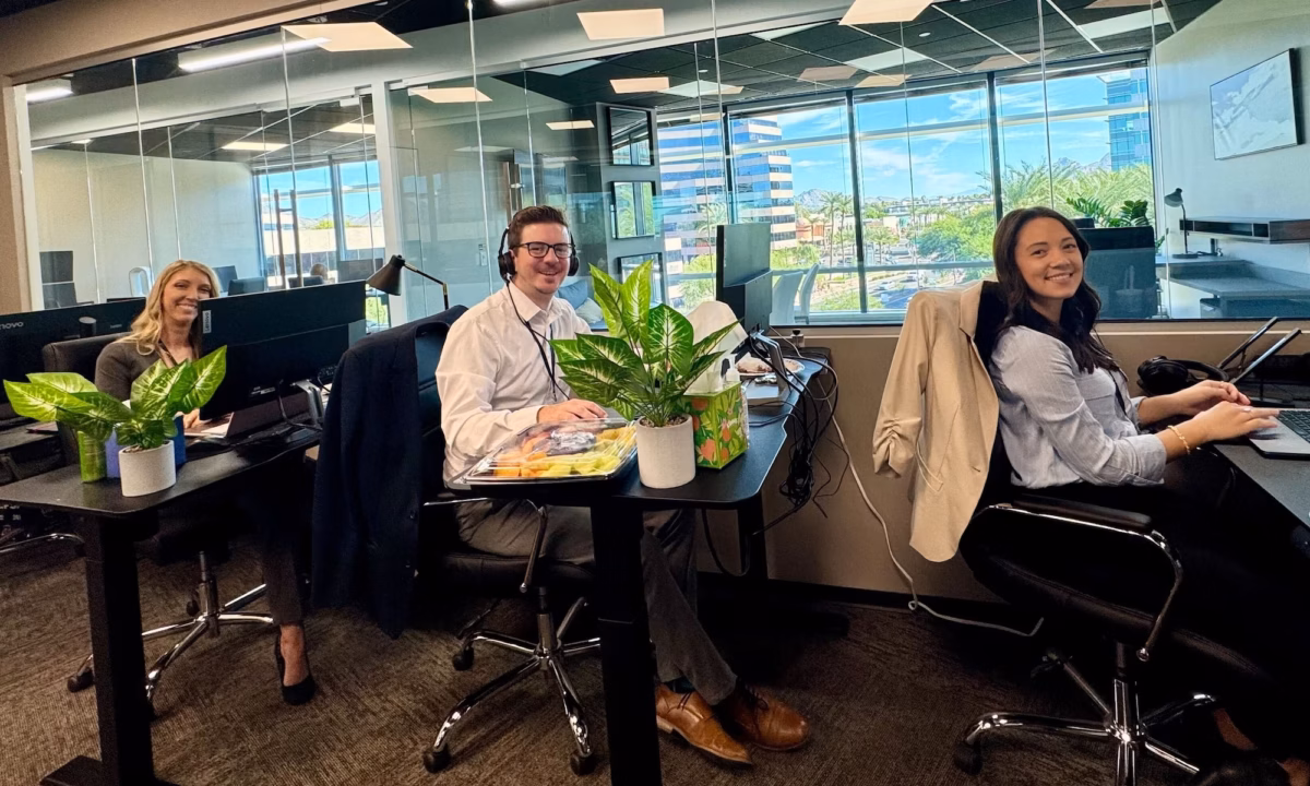 Three staff members in front of desktop computers with headsets on demonstrate the dedication behind the hundreds of Luxury Presence reviews on Google and other platforms