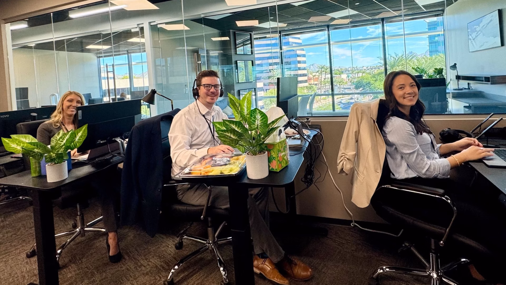 Three staff members in front of desktop computers with headsets on demonstrate the dedication behind the hundreds of Luxury Presence reviews on Google and other platforms