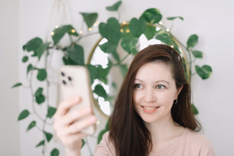 A real estate agent holds up her phone taking a selfie and demonstrating how to build a brand on instagram and linkedin