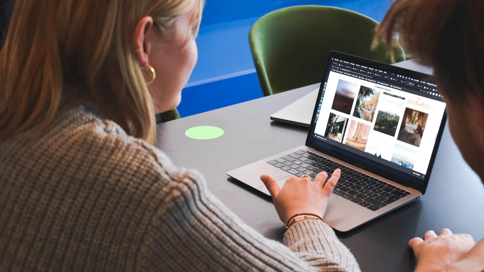 Two agents look at a laptop screen featuring many real estate email templates to choose from