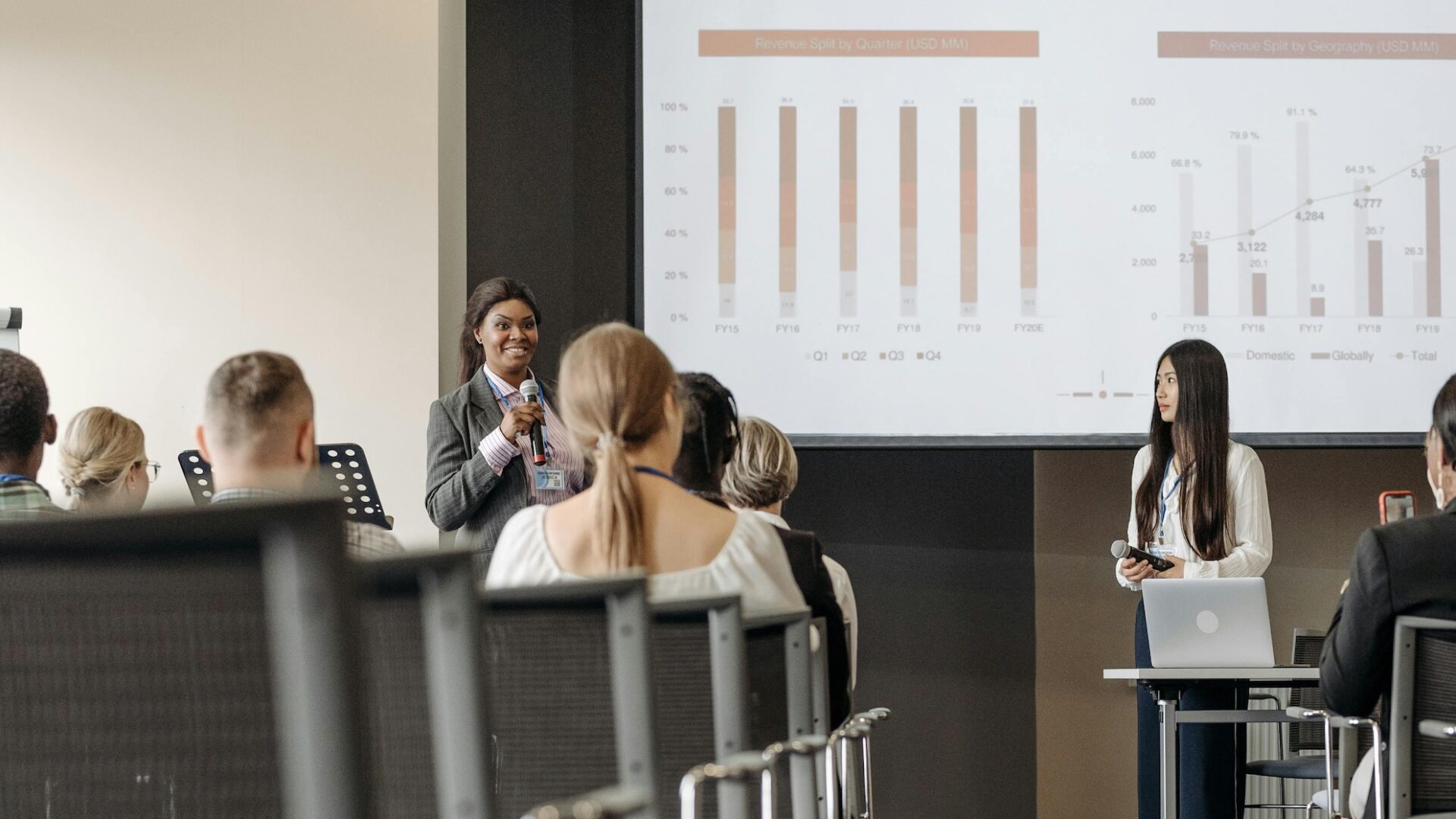 A real estate broker stands in front of a group of agents demonstrating her thought leadership skills