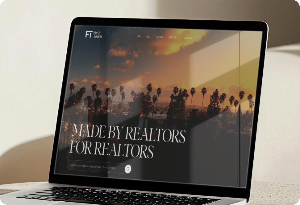 Laptop sitting open with the FirstTeam brokerage homepage up on the screen