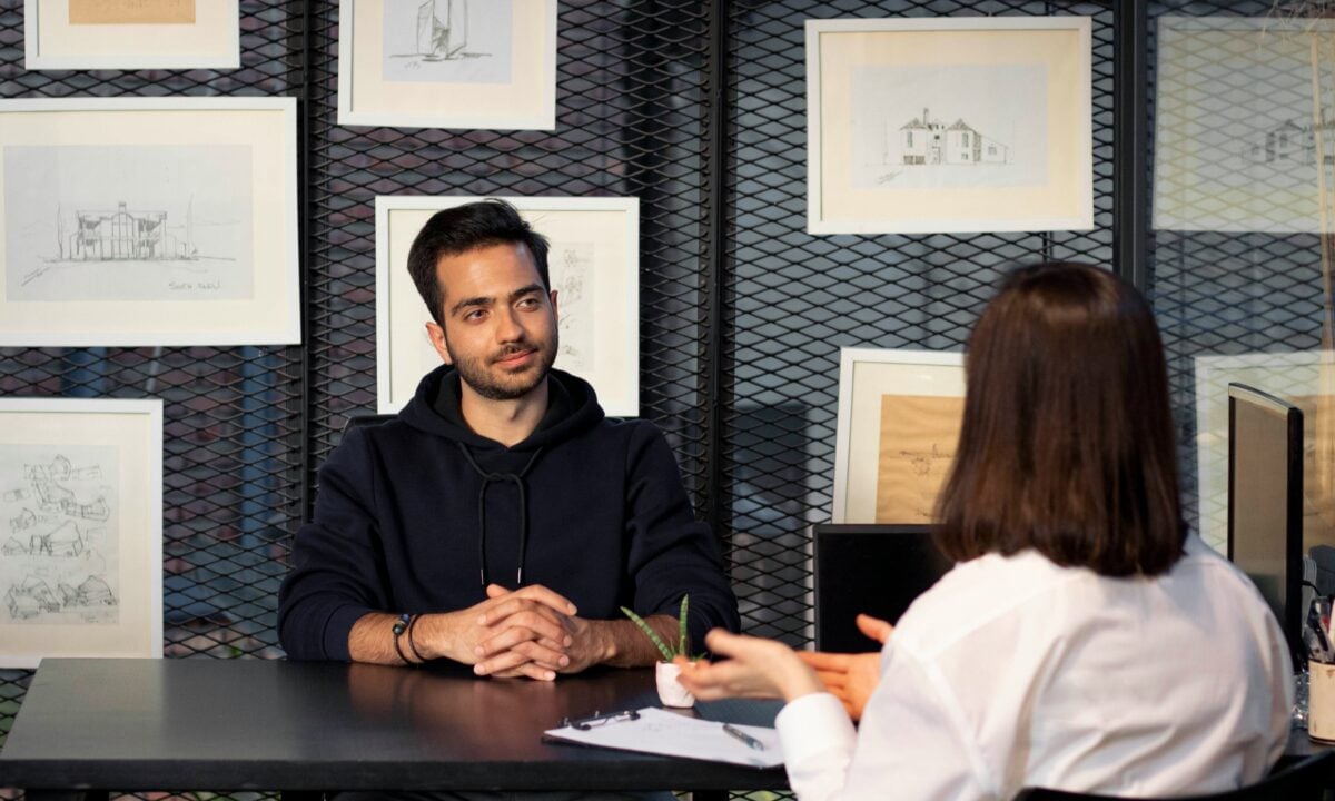A real estate broker sits with a candidate to ask real estate interview questions.