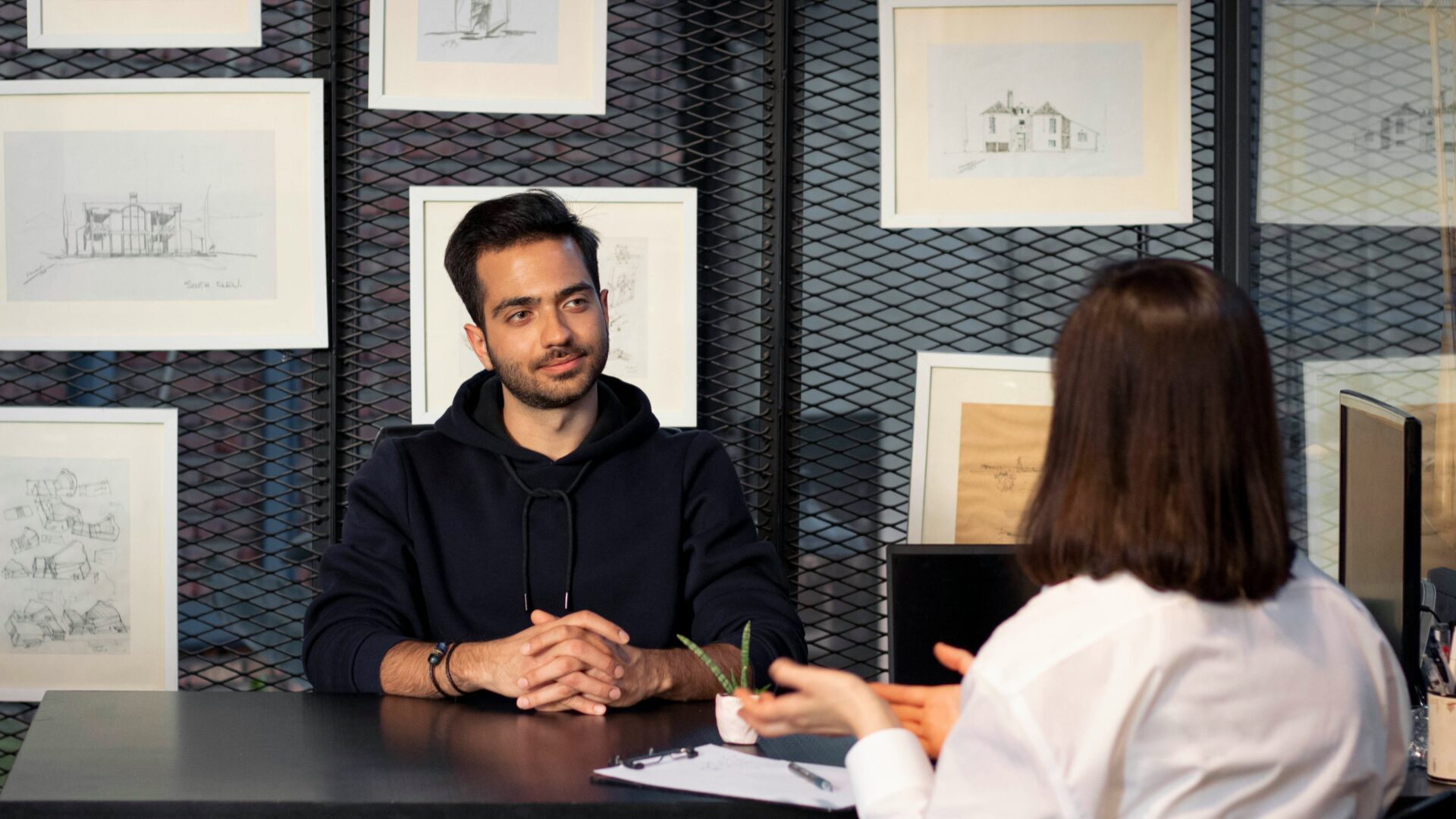 A real estate broker sits with a candidate to ask real estate interview questions.