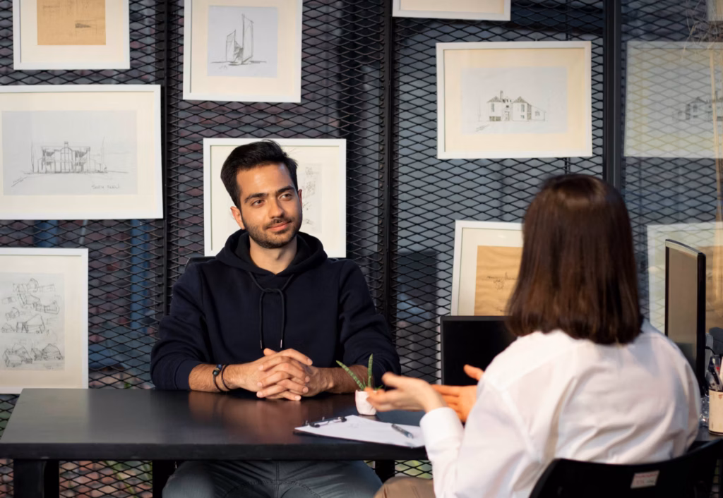 A real estate broker sits with a candidate to ask real estate interview questions.