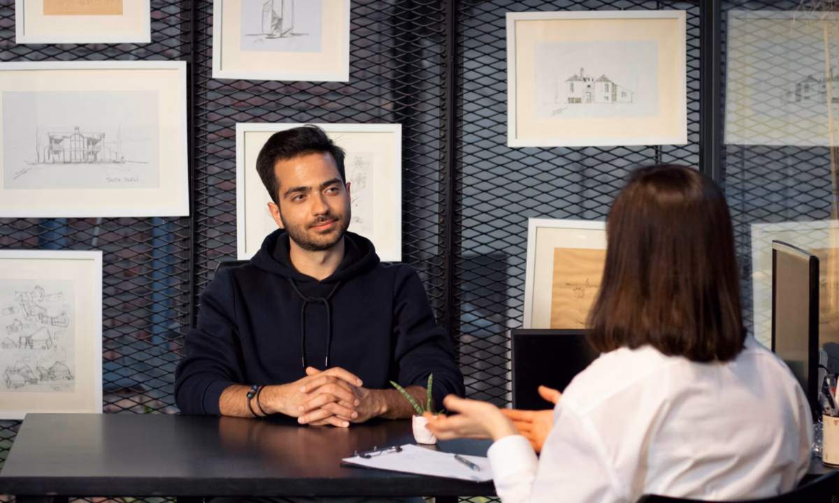 A real estate broker sits with a candidate to ask real estate interview questions.