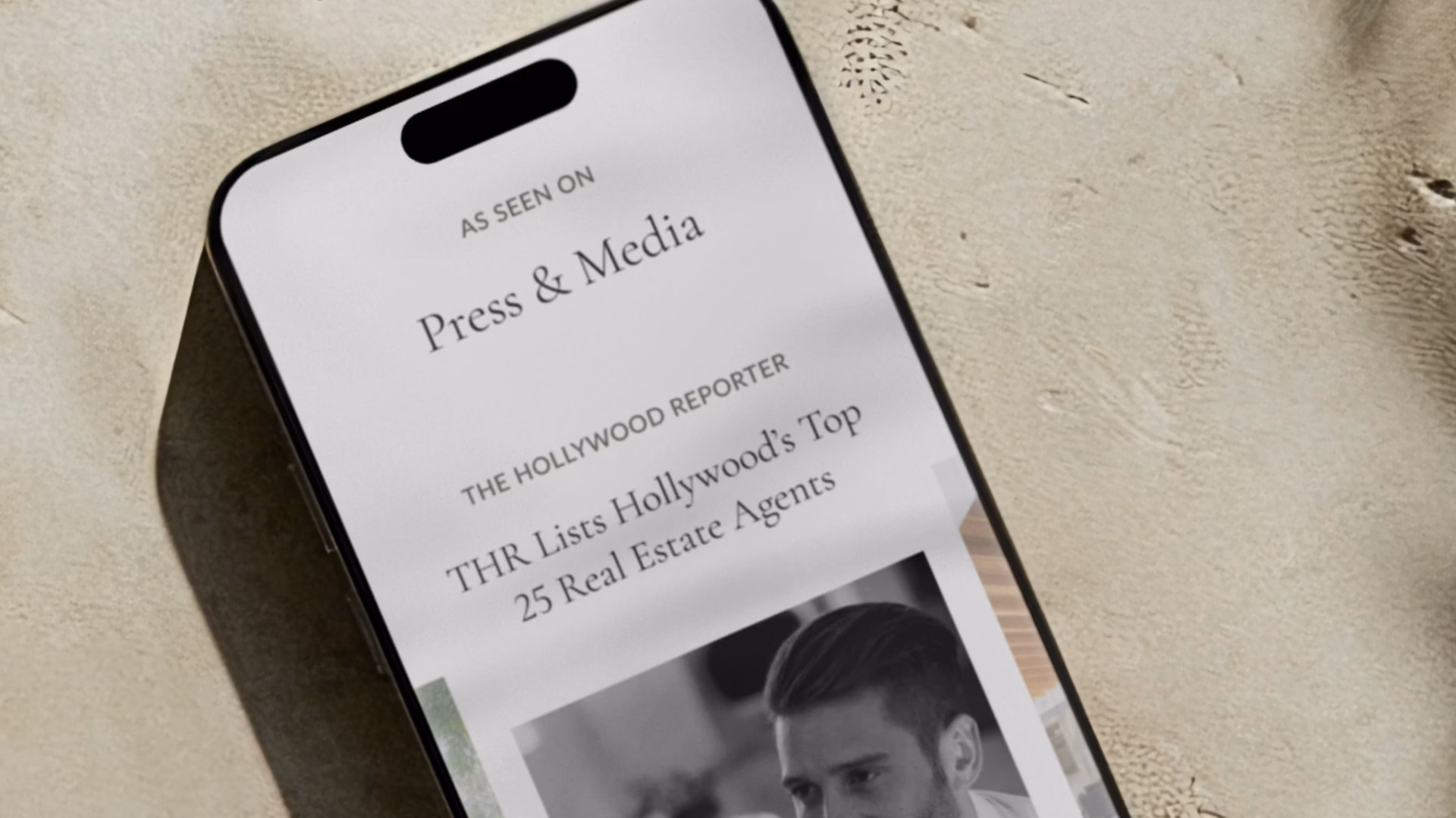 A smartphone with a press release for a real estate website on the screen