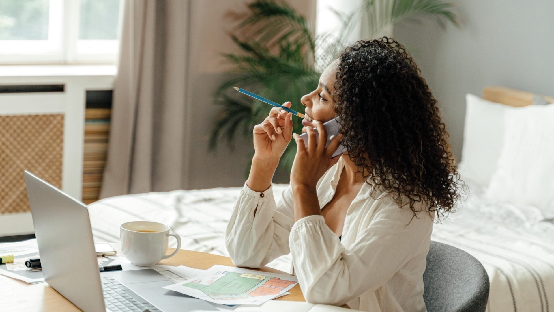 real estate agent on the phone sits at a desk trying to decide between luxury presence vs lofty as a website provider