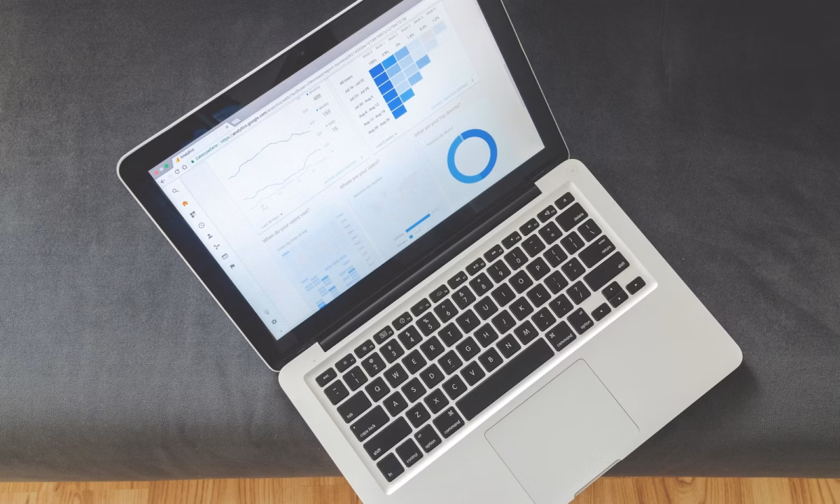 A laptop sits open on a grey surface with Google Analytics open, showing the impacts of real estate SEO companies on agent and broker website visibility