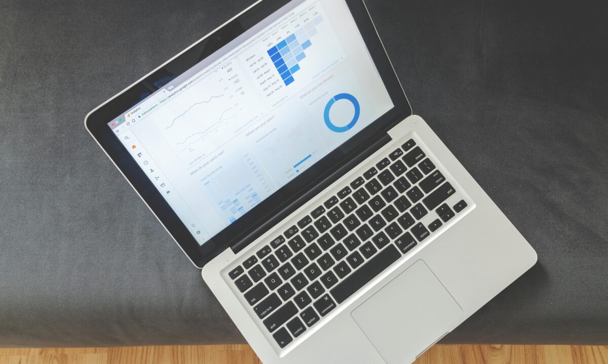 A laptop sits open on a grey surface with Google Analytics open, showing the impacts of real estate SEO companies on agent and broker website visibility