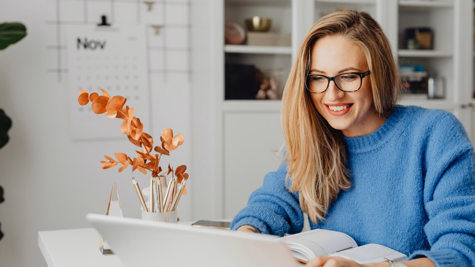 A real estate agent smiling at her laptop because her Luxury Presence website generated a new lead for her business