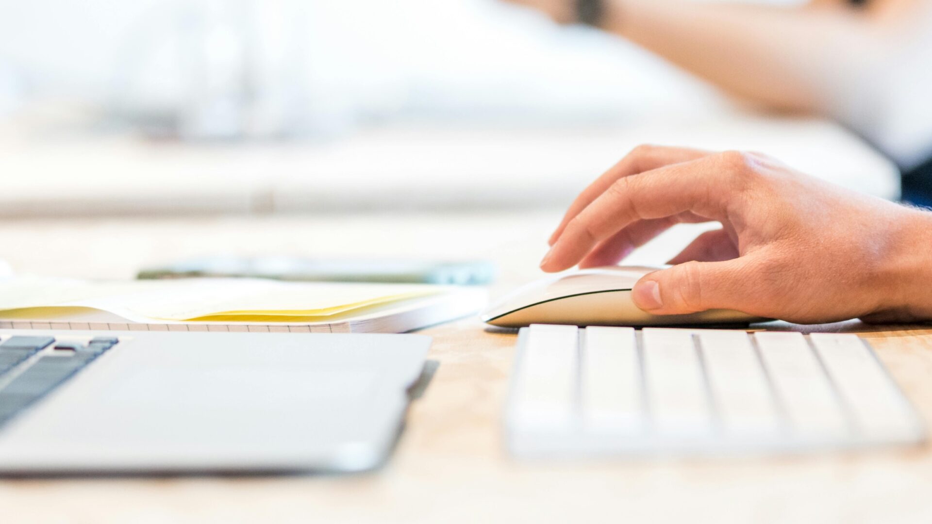 real estate agent's hand on a mouse in front of a laptop