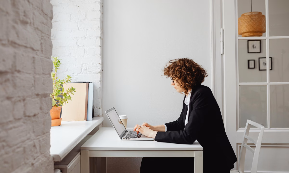 Real estate agent looking at the pros and cons regarding Luxury Presence vs. Real Geeks on a laptop